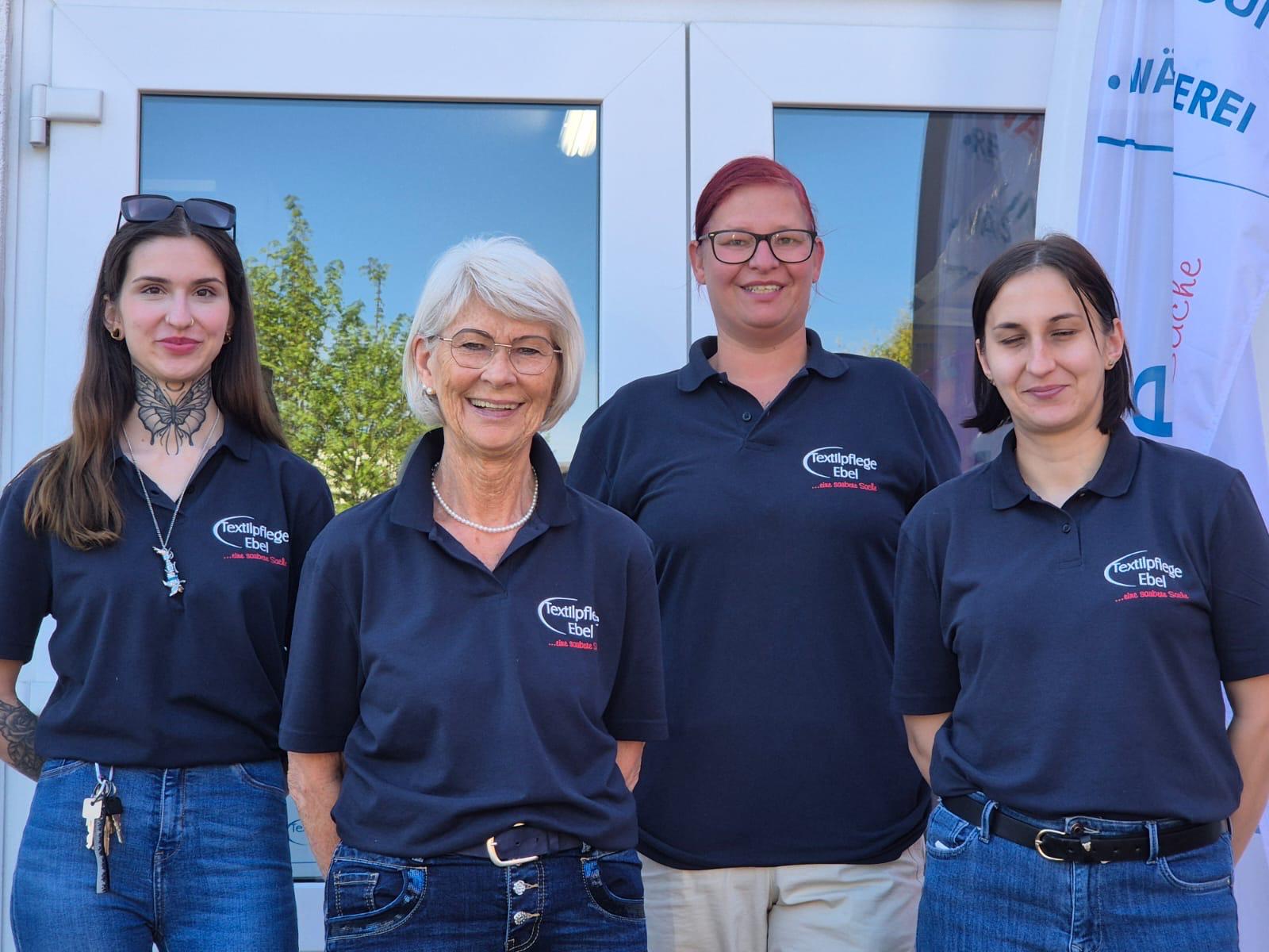Das Team vor der Textilpflege-Ebel Filiale in Tostedt, es sind 4 Personen auf dem Bild zu erkennen.